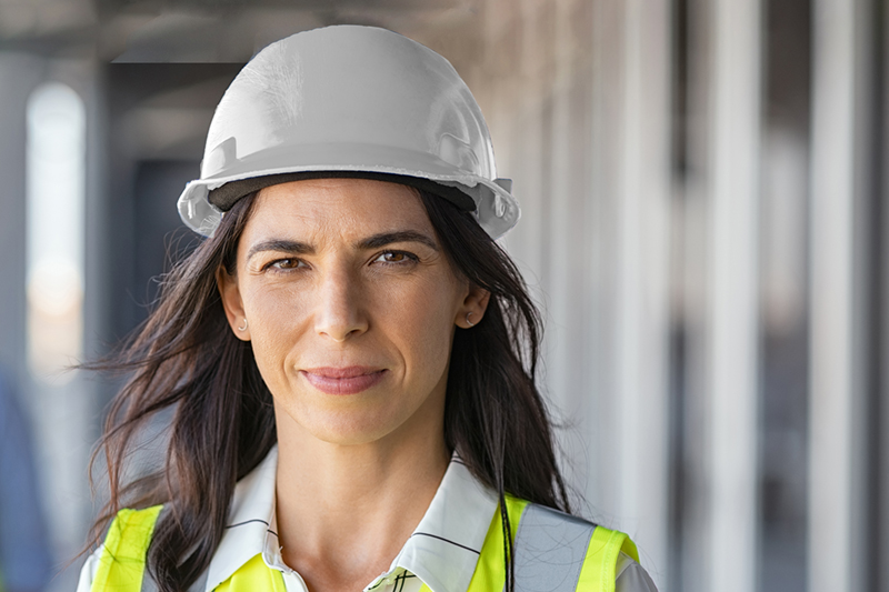 A utility worker posing for a photo in a white hardhat