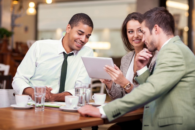 Three people looking at tablet