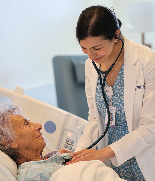 a nurse checking a patient's heart with a stethescope