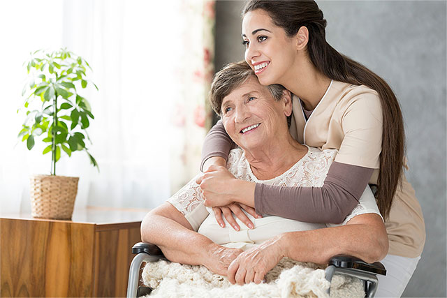 Nurse and Patient in a wheel chair hugging